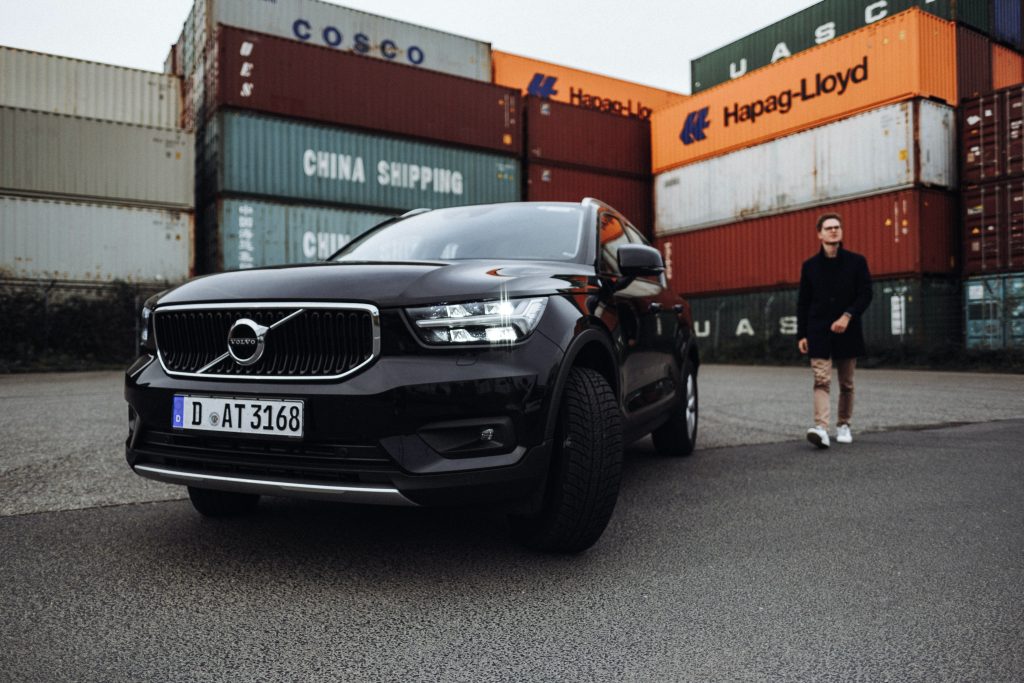 Young man standing behind a Volvo SUV Car XC40 in the Harbour of Düsseldorf