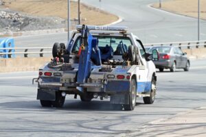 a tow truck, part of the car towing vs. shipping debate, driving on a highway