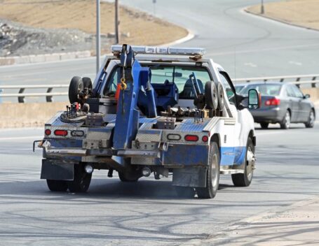 a tow truck, part of the car towing vs. shipping debate, driving on a highway