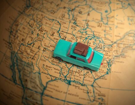 Toy car sitting on top of a map of the United States.