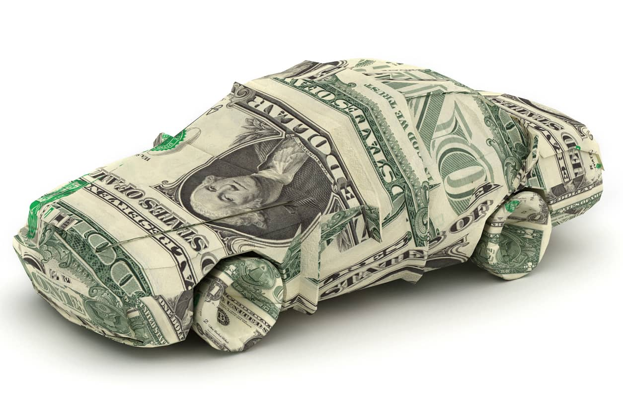 An origami car composed of one-dollar bills against a white background.