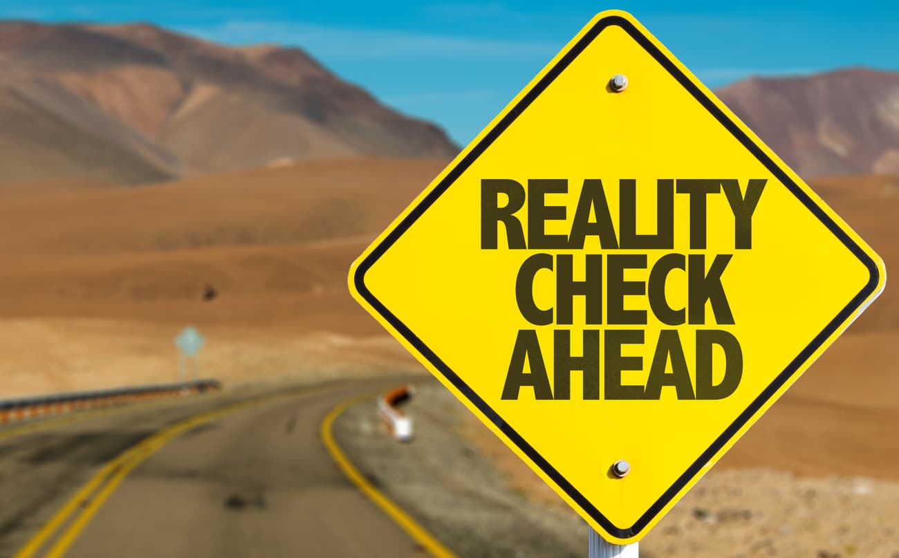 Open road with a sign reading “Reality Check Ahead”