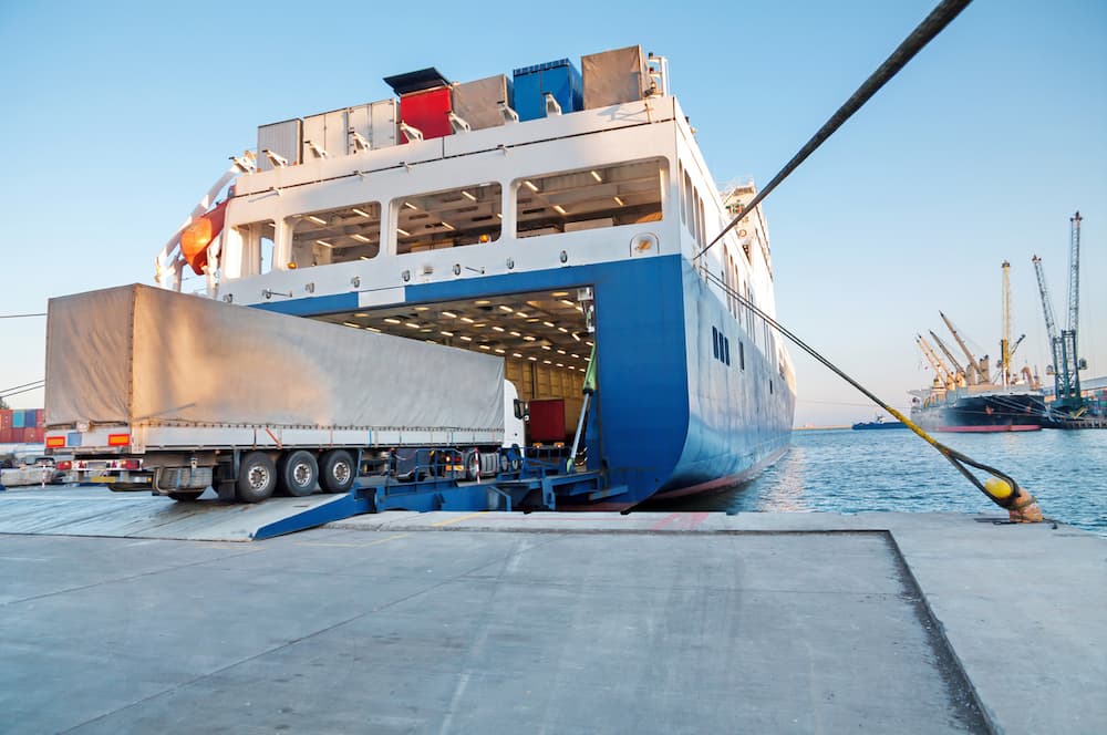 cars being unloaded from a docked roll on/roll off ship of a car transport international company.