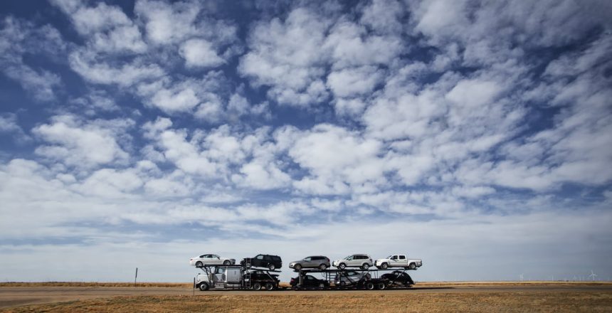 Cars being hauled under blue sky