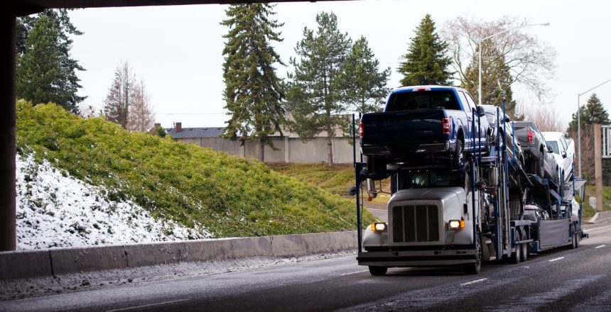 a car shipping truck moving vehicles in the winter when auto transport prices are lower