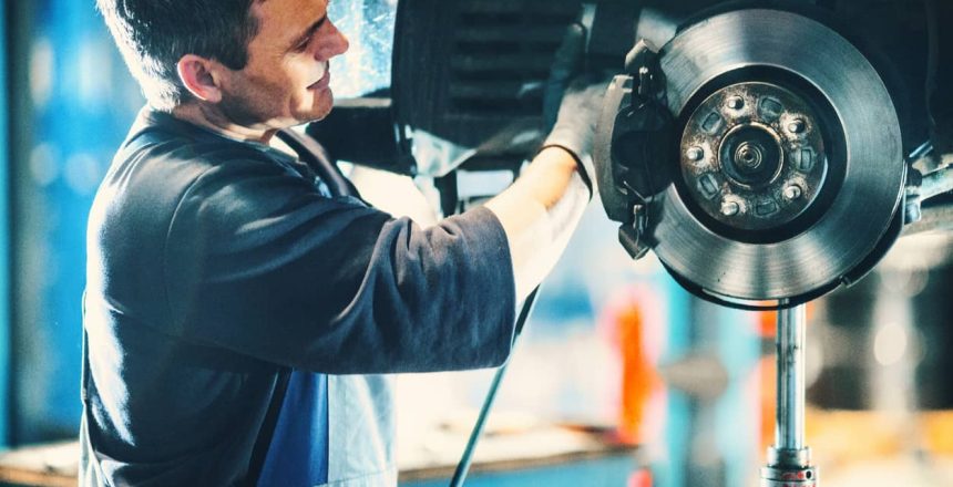 Mechanic installing new brake pads on a vehicle.