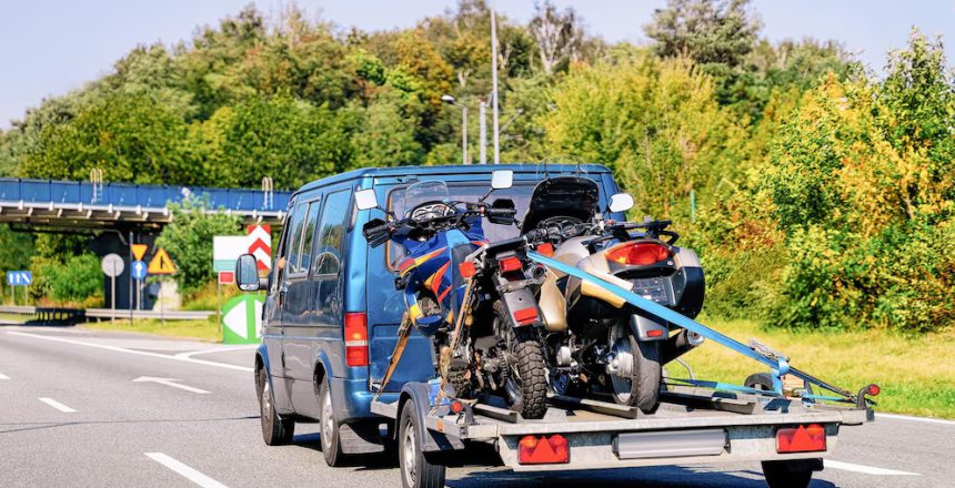 Mini van pulling a motorcycle