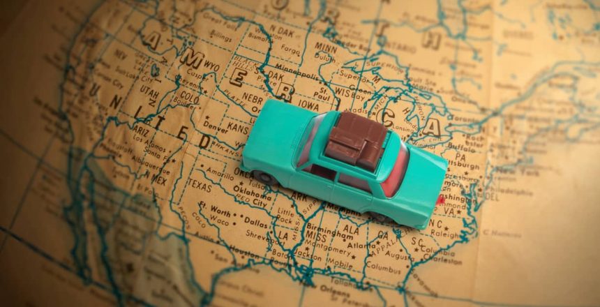 Toy car sitting on top of a map of the United States.