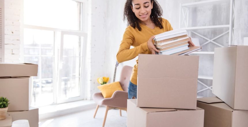 curly-hair college-aged student getting packed up while moving for university