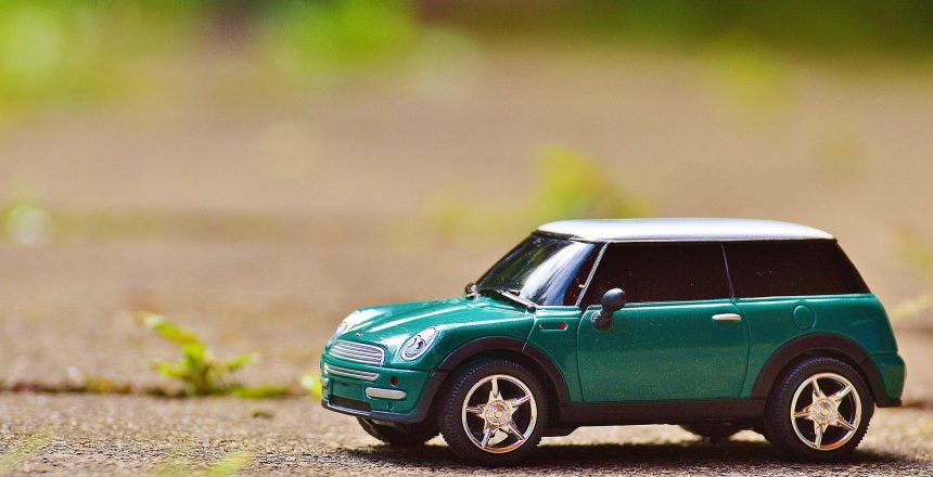 Green Scale Model Car on Brown Pavement