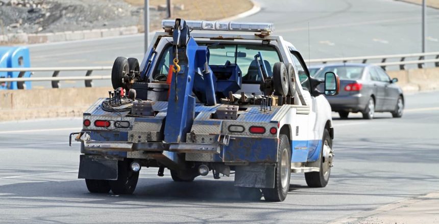 a tow truck, part of the car towing vs. shipping debate, driving on a highway